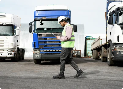 Logistics officer checking trucks at a depot